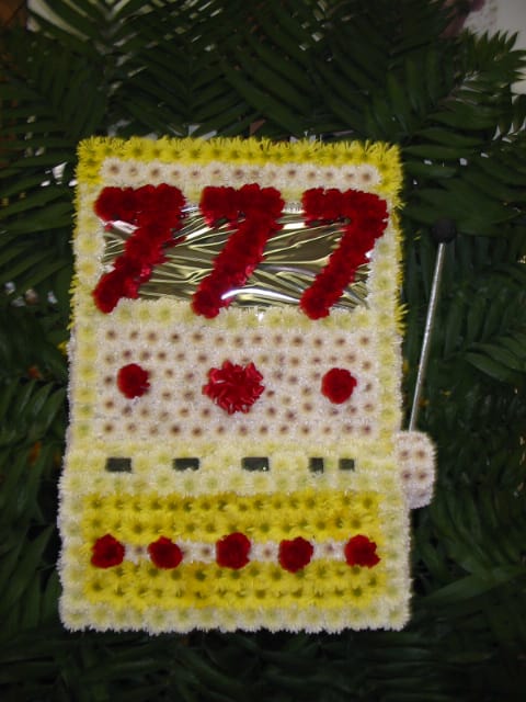 Floral tribute shaped like a bus with red and white flowers