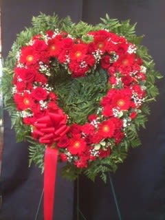 Heart-shaped red floral wreath with a ribbon bow
