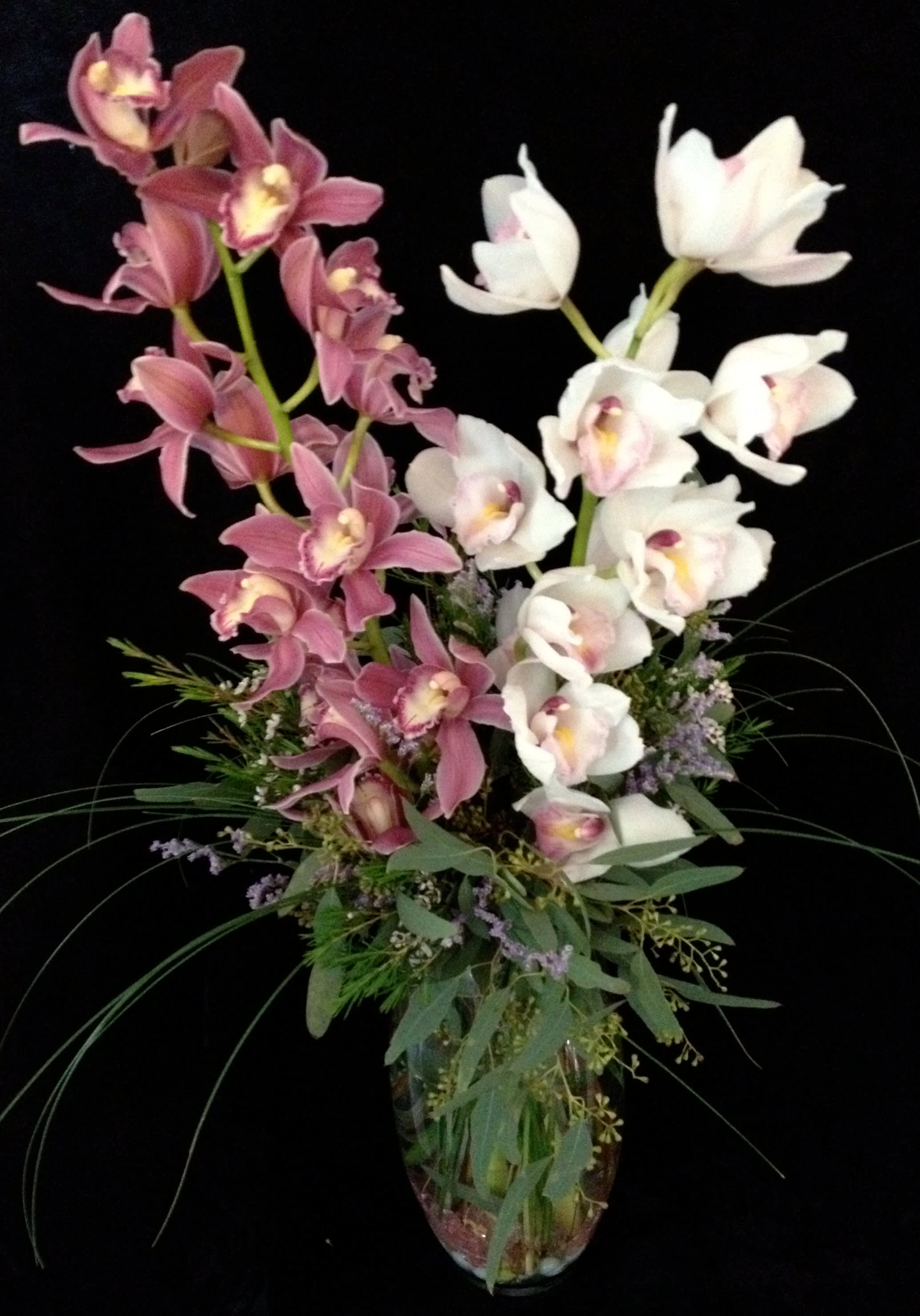 Pink and white orchids in a glass vase