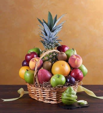 Fruit basket with a pineapple and assorted apples in a wicker basket