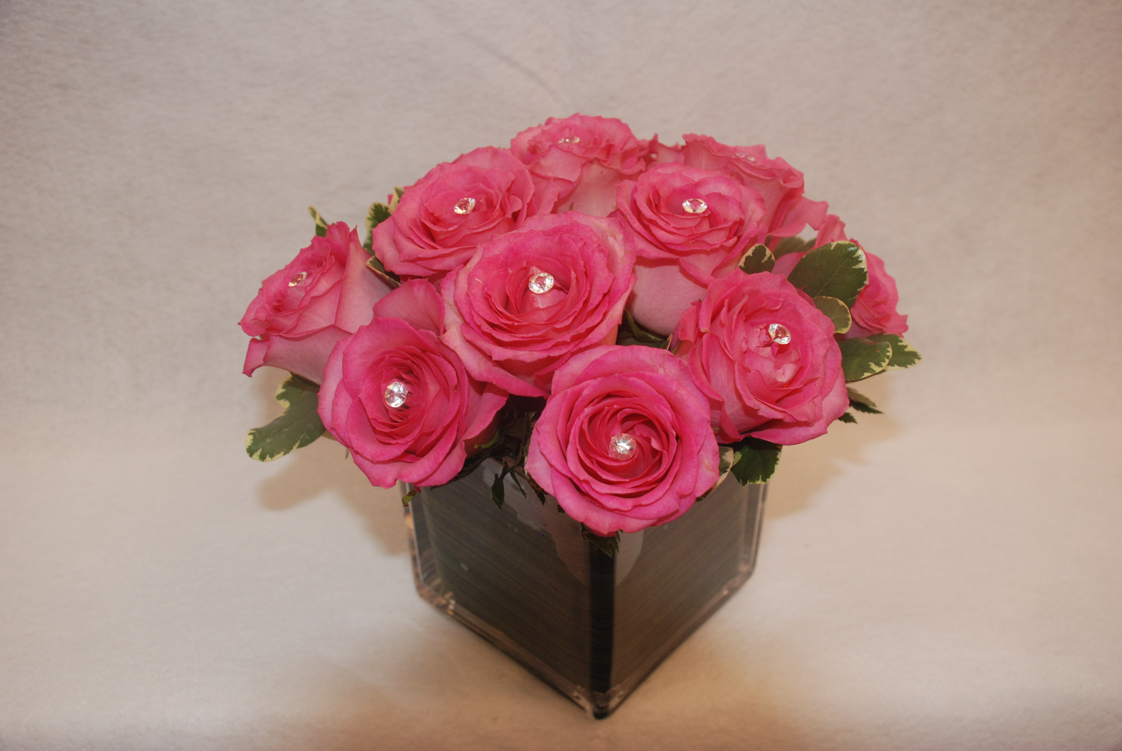Pink roses arranged in a square glass vase