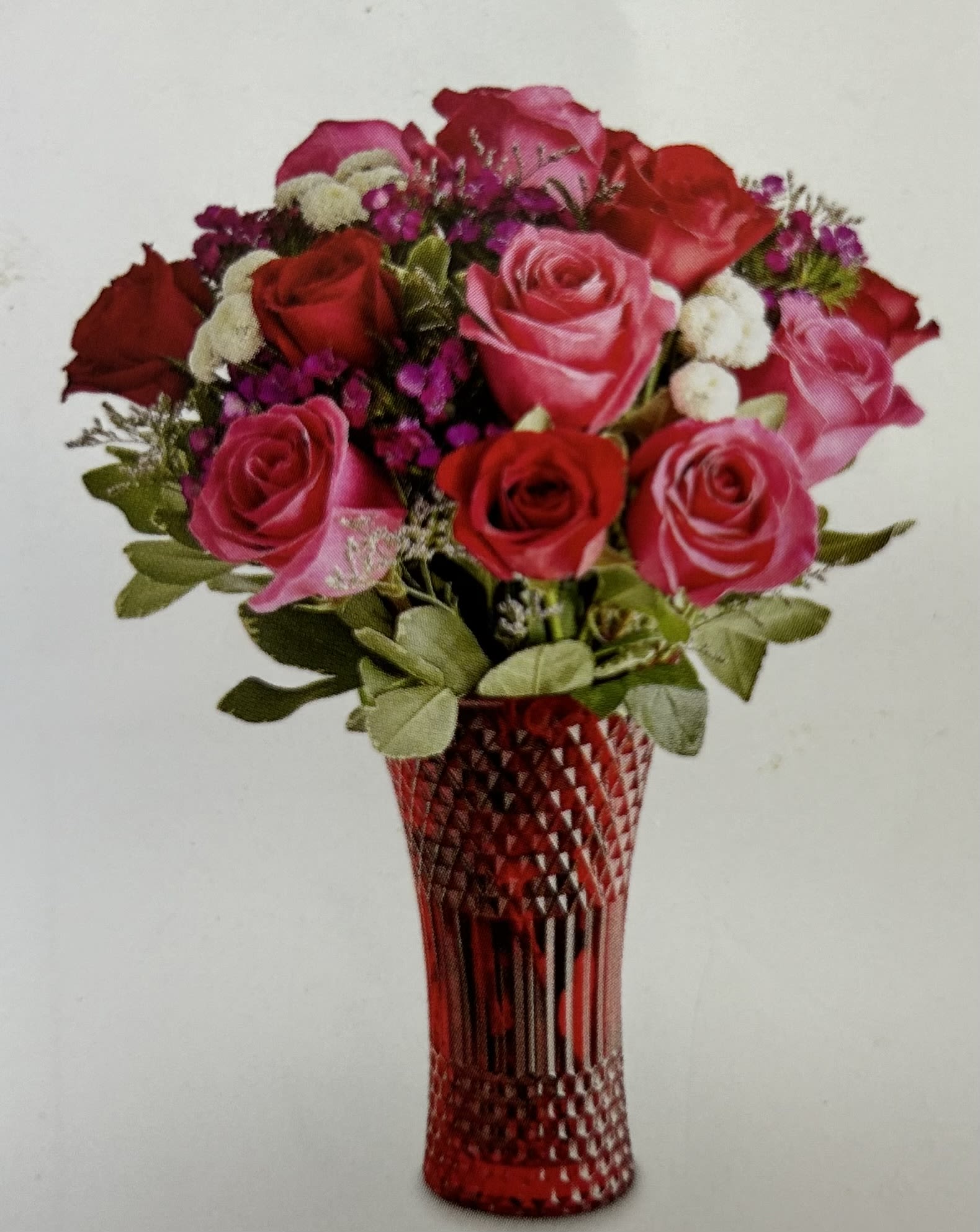 Bouquet of red and pink roses in a red cut-glass vase