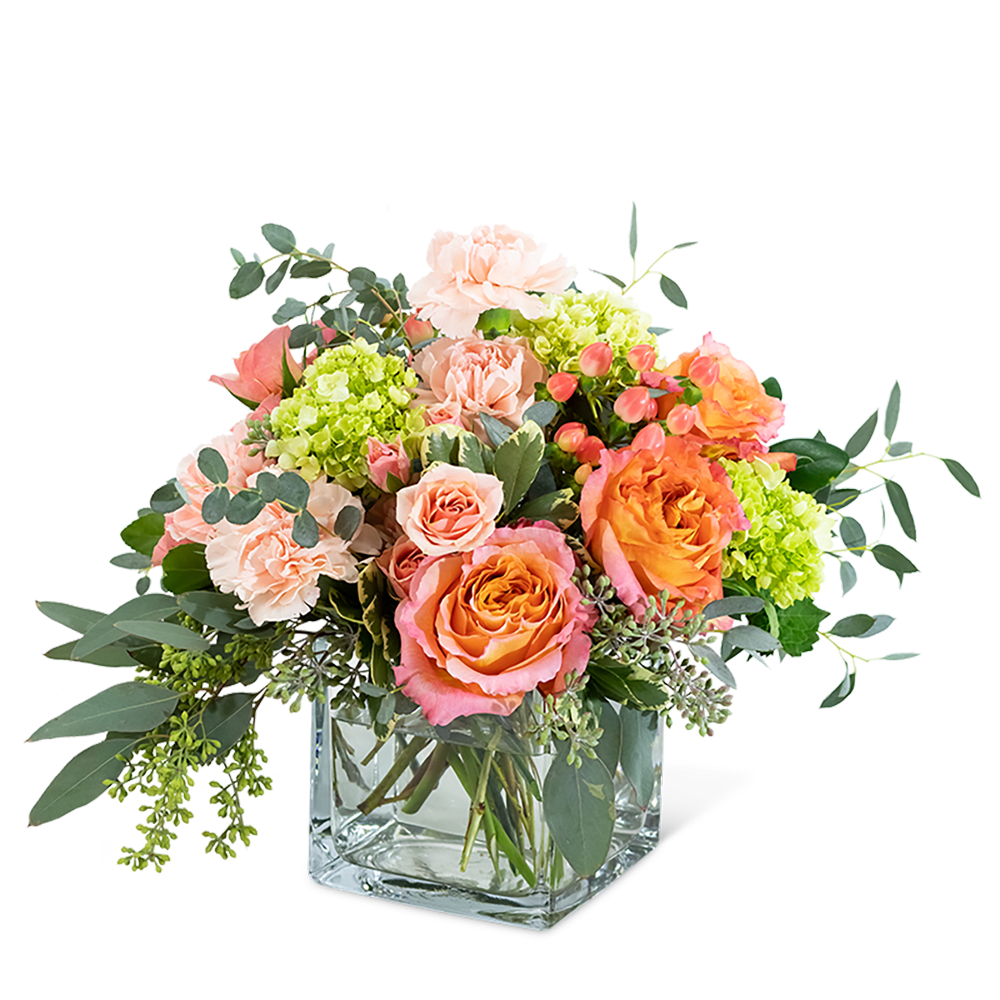 Mixed pink and orange bouquet in a clear square vase