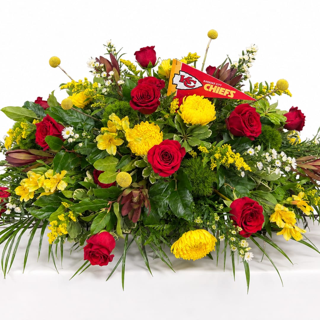 Red roses and yellow mums in a large arrangement with a Kansas City Chiefs pennant