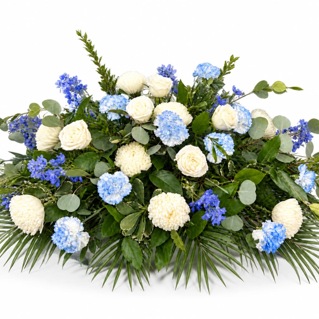 Blue and white floral arrangement with roses and pompons on a white background