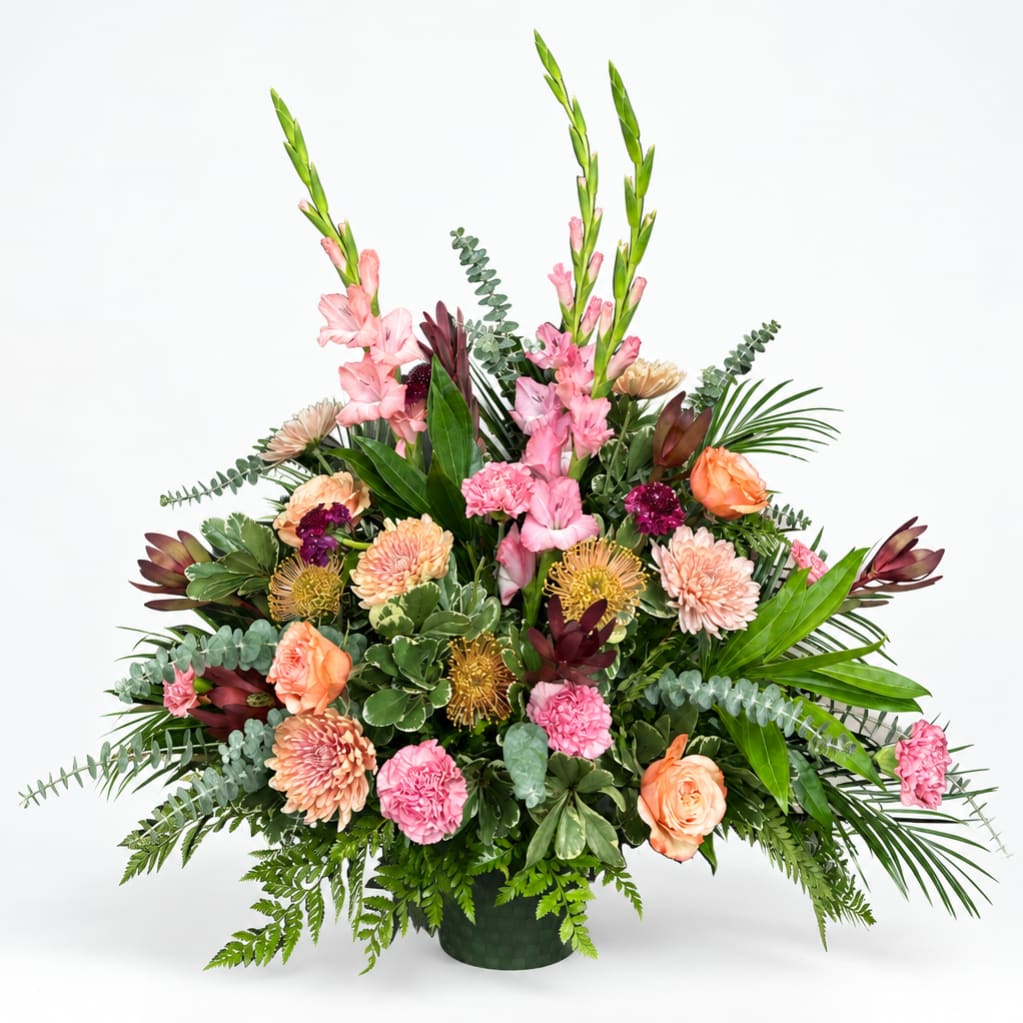 Large pink and peach floral arrangement in a dark vase