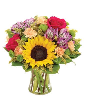 Bouquet with a sunflower, roses, and alstroemeria in a glass vase
