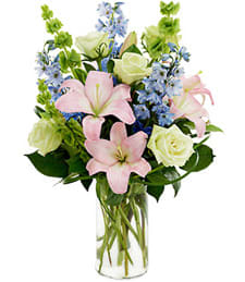 Pink lilies and white roses in a clear glass vase