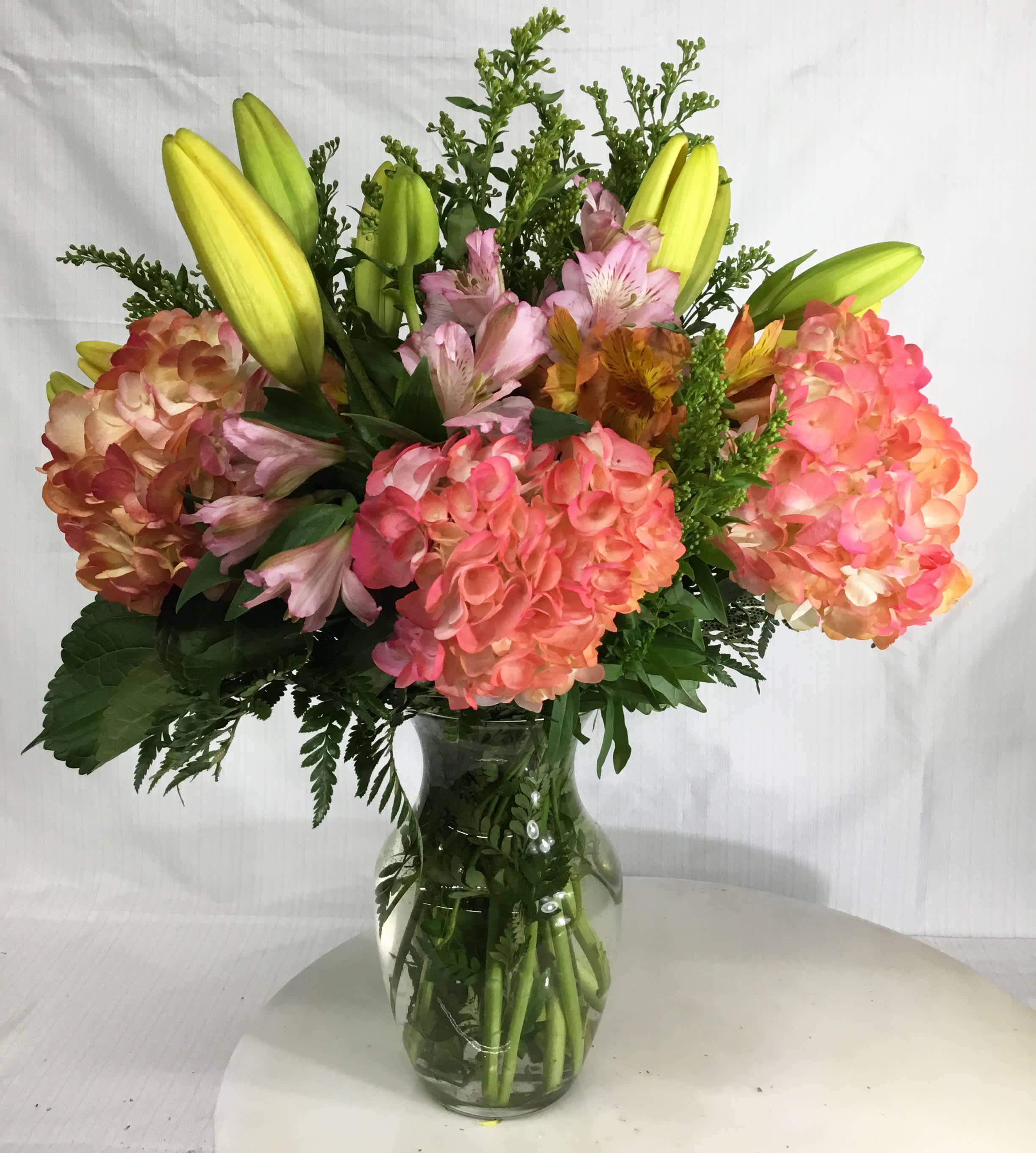 Bouquet of pink hydrangeas and yellow lilies in a glass vase