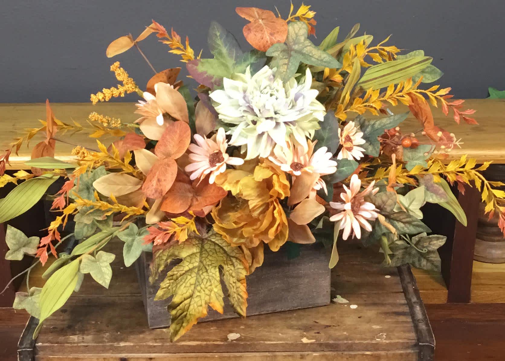 Autumn floral arrangement with white and peach daisies in a wooden box