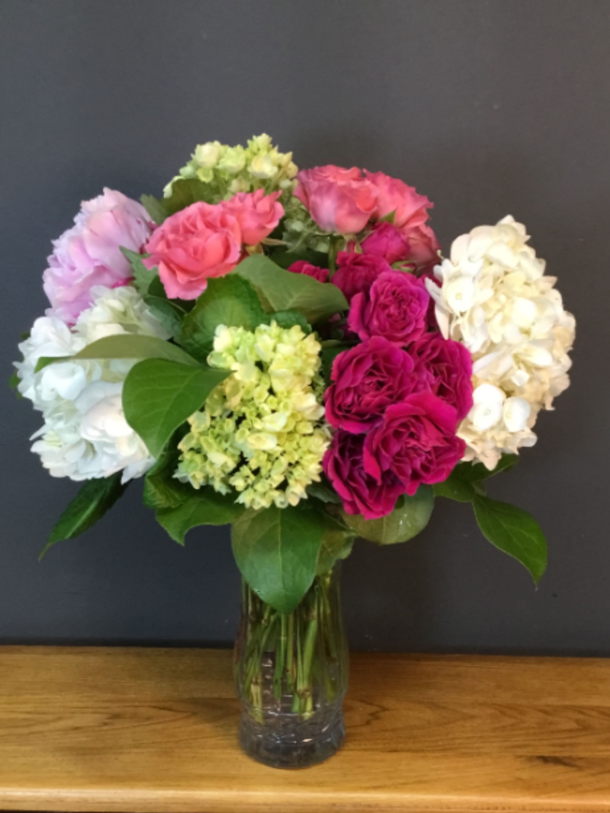 Sweet and Pretty by FTD - Carnations, Hot pink roses, alstromeria and greens in a clear vase.