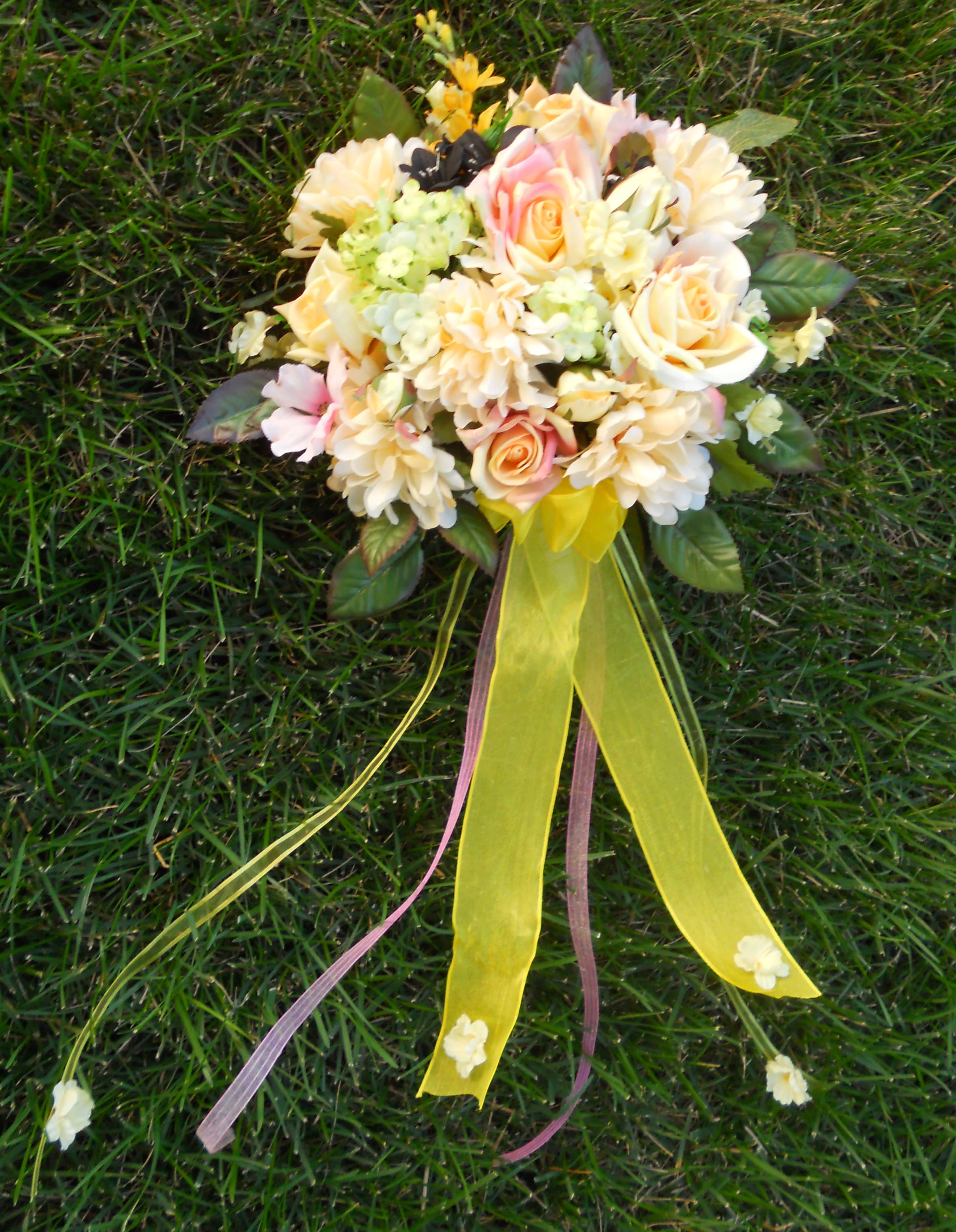 Pastel bouquet of roses and daisies with long yellow ribbons