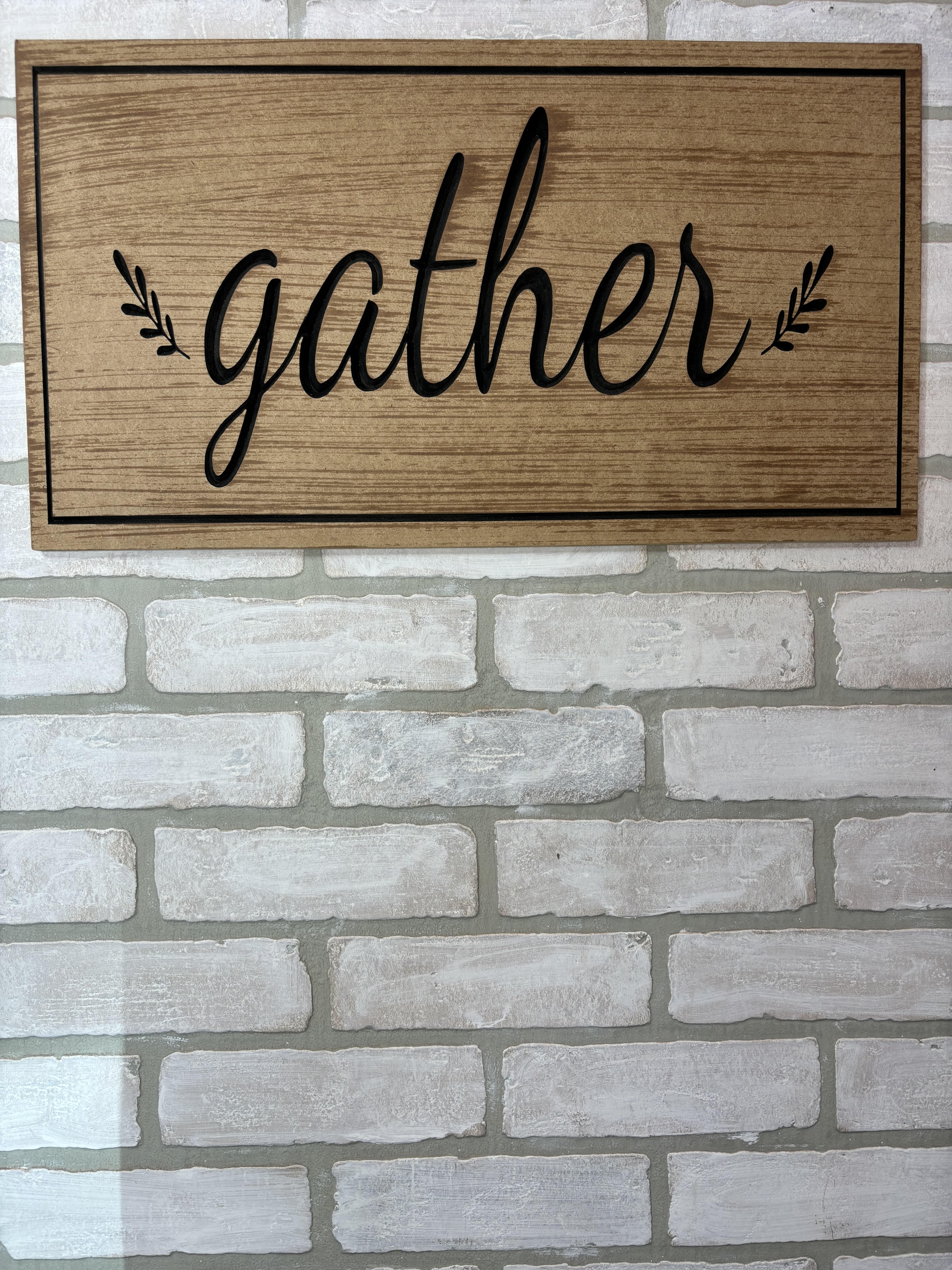 Wooden wall sign with the word "gather" in black script
