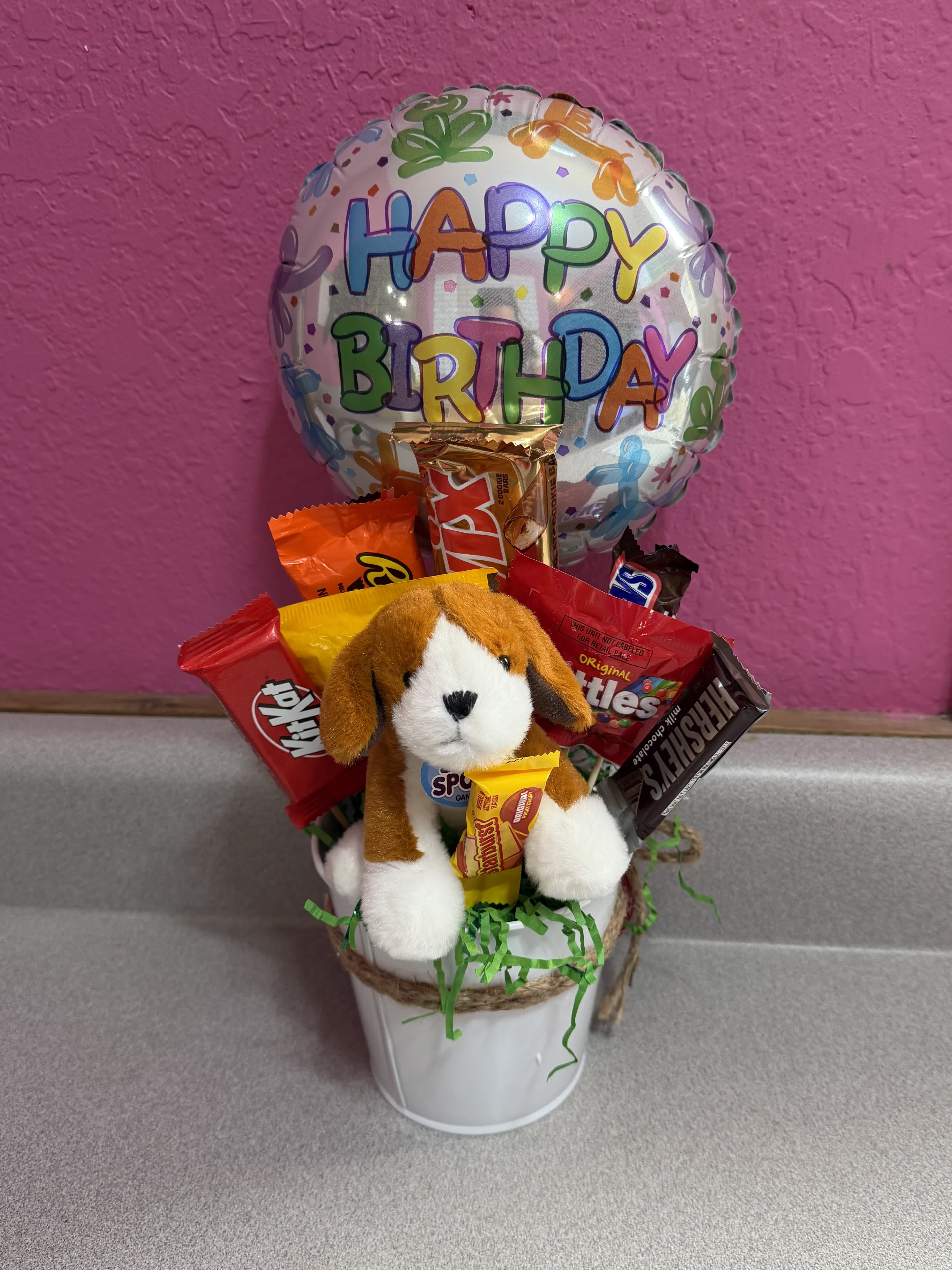 Birthday balloon with candy bouquet and plush dog in a white bucket