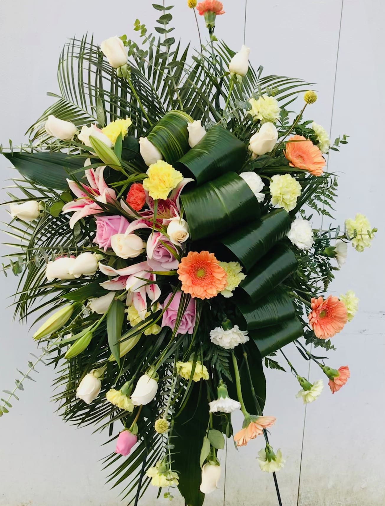 Large standing floral spray with white lilies, roses, and gerbera daisies