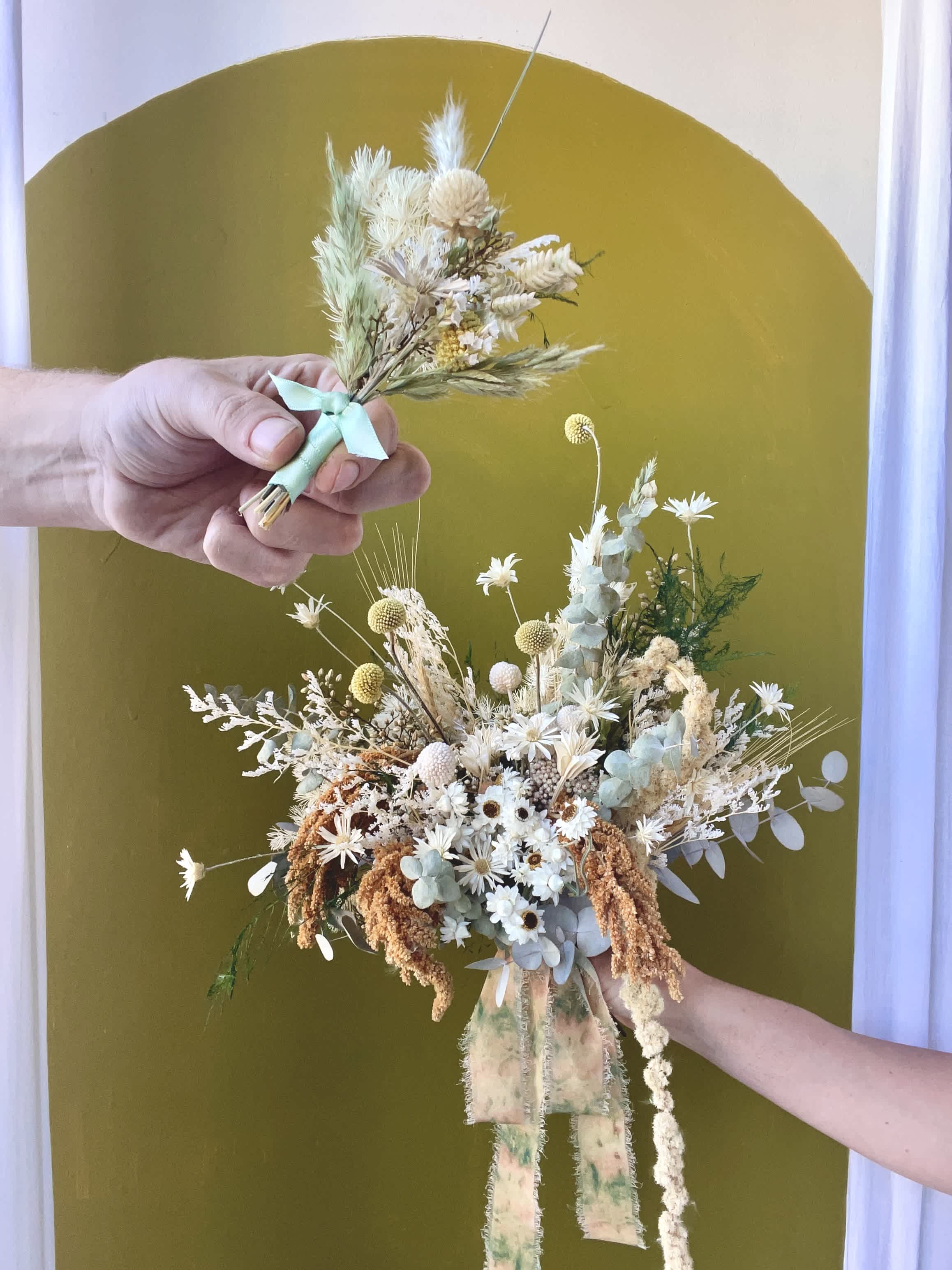 Dried flower bouquet with white and pale blue blooms tied with ribbon