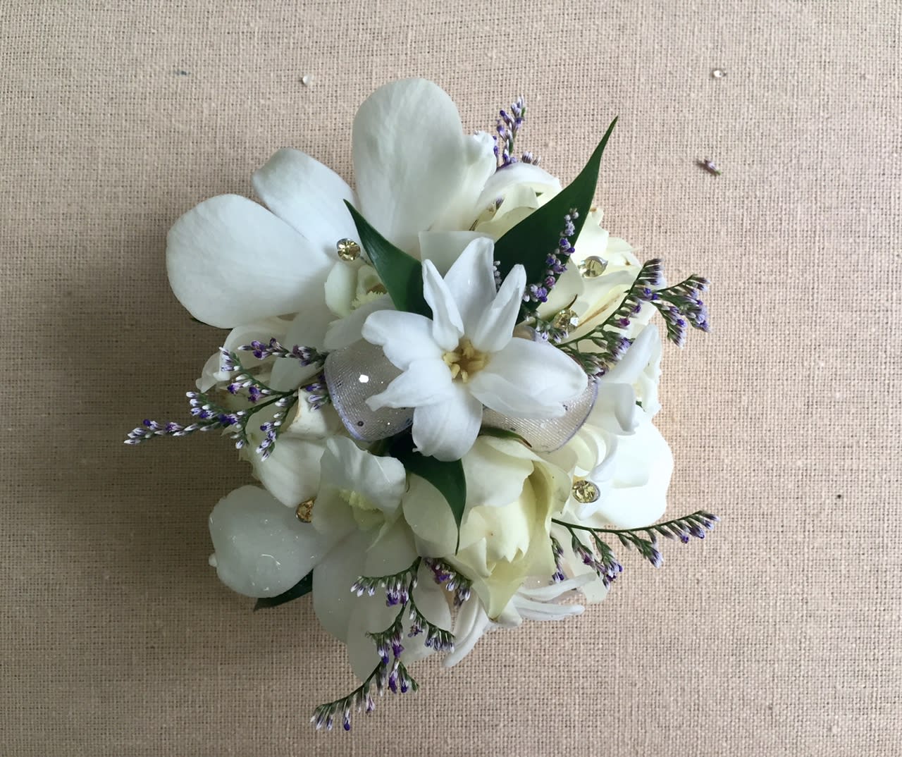 White floral bouquet with purple accents and ribbon