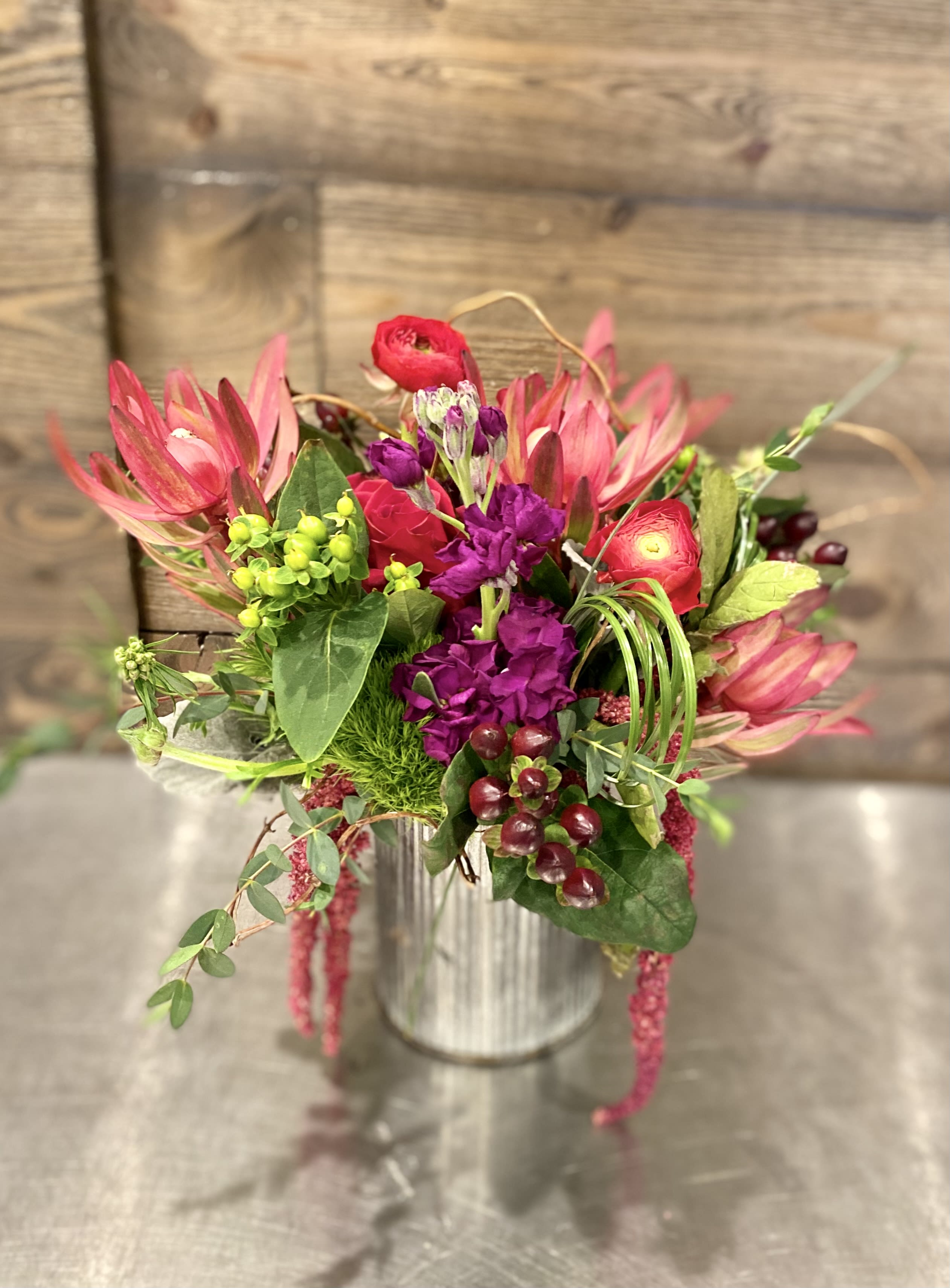 Pink and purple floral arrangement in a metal vase