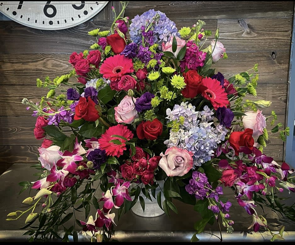 Large mixed bouquet with roses, gerbera daisies, hydrangeas, and orchids in a vase