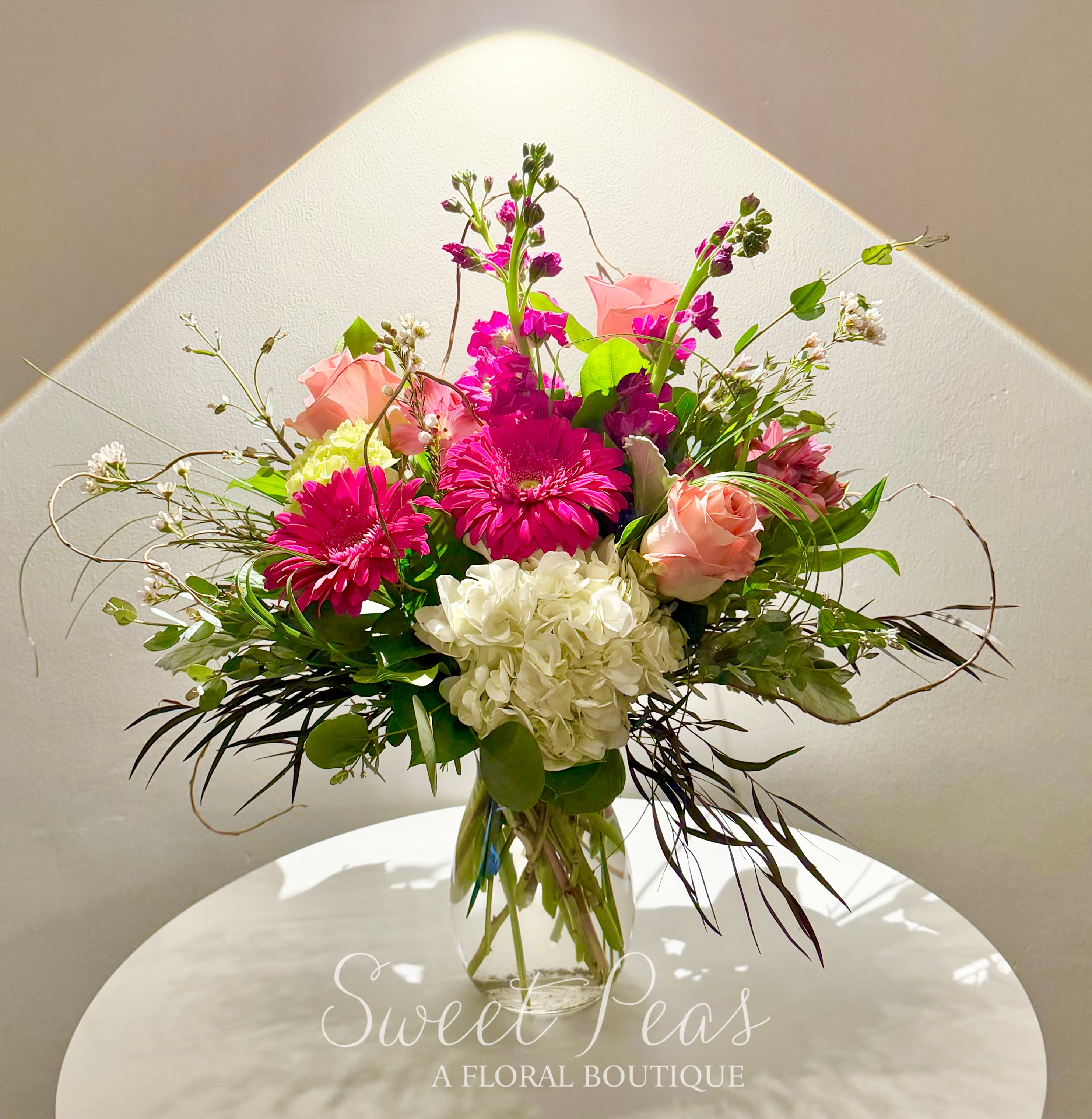 Mixed pink and white flower arrangement in a clear glass vase