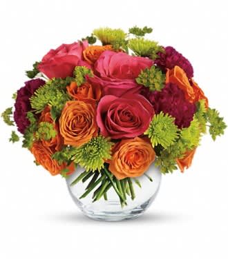Bouquet of pink, orange, and green flowers in a clear glass vase