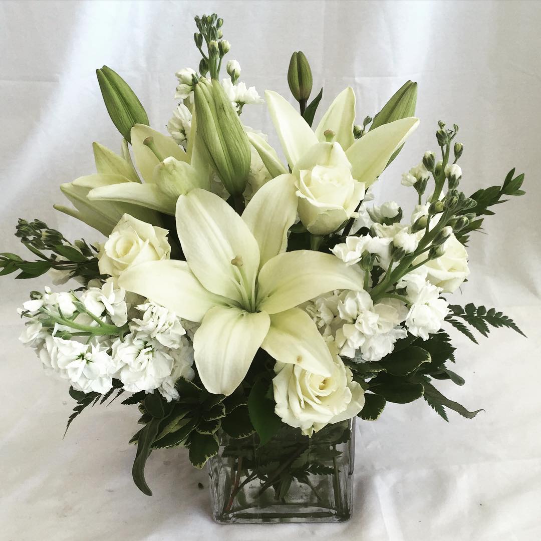 Pure White Bouquet - Send someone a bit of heaven with this beautiful bouquet. Luxurious crème roses and pure white lilies paint a peaceful picture inside a cube.