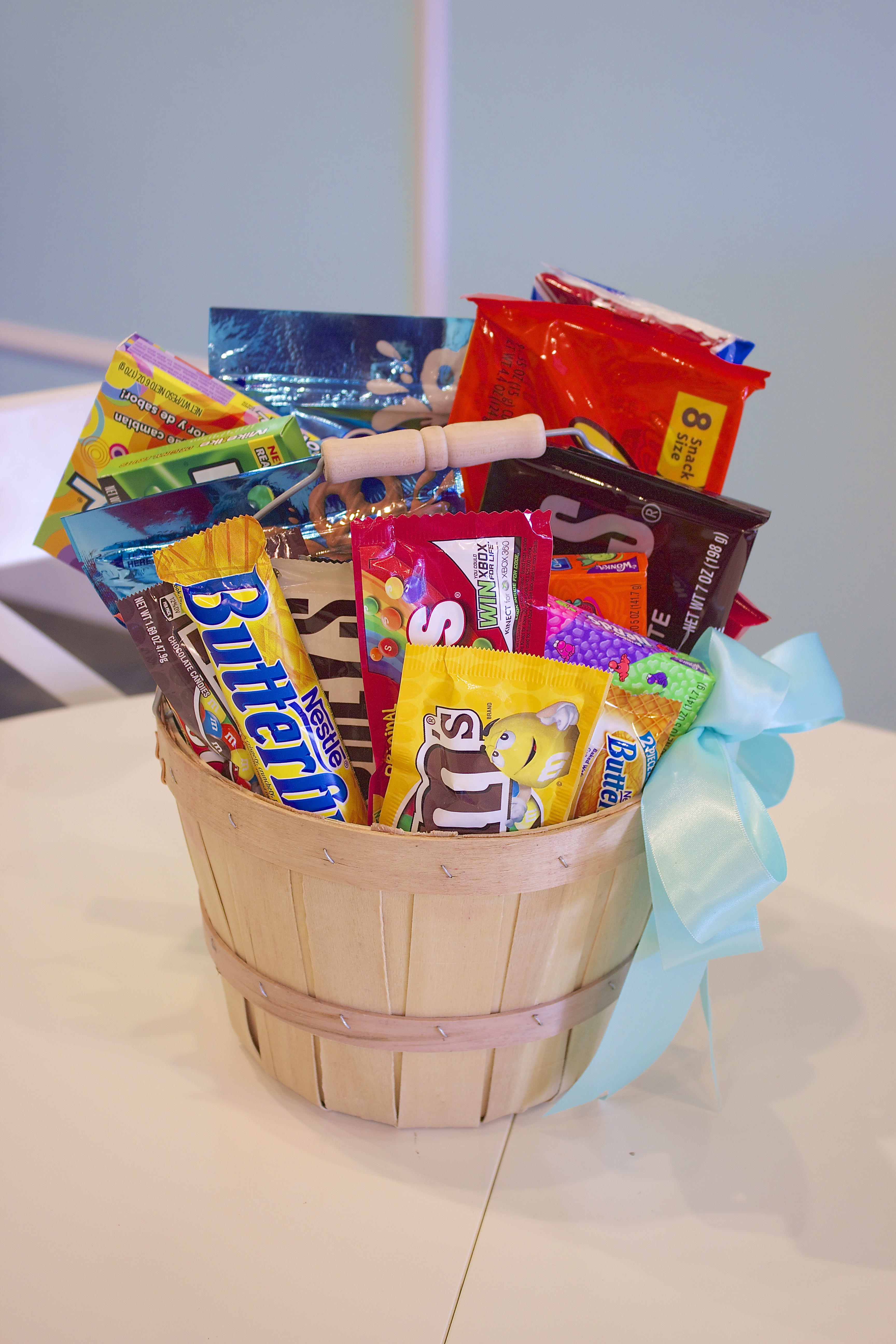 Basket of assorted candy bars and snack packs tied with a blue ribbon