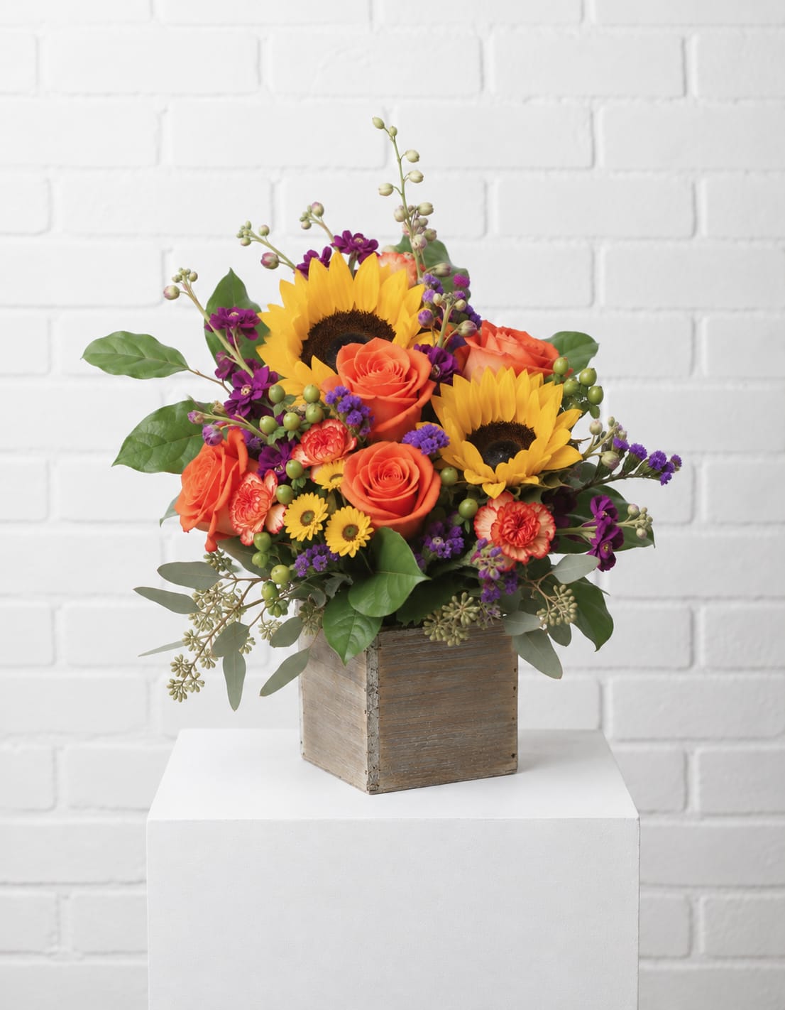 Sunflower and orange rose arrangement in a wooden cube vase