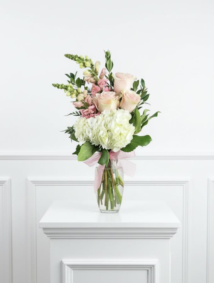 Bouquet of pale pink roses and white hydrangeas in a clear glass vase