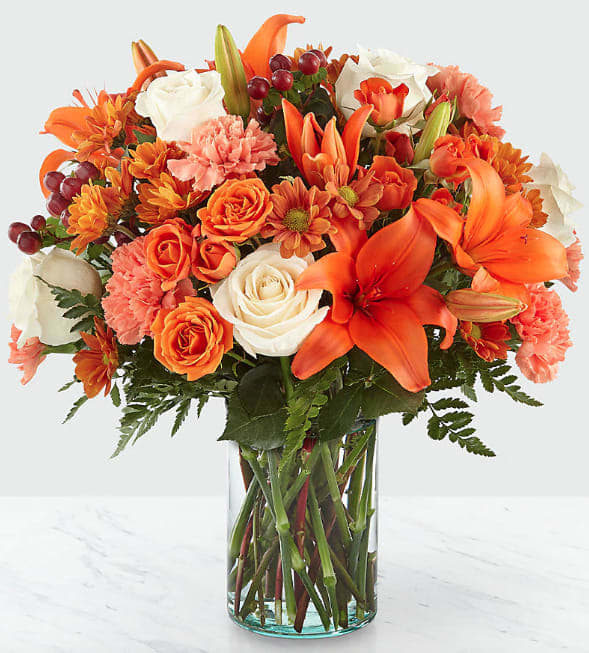 Falling for Autumn - The harvest season just got even more beautiful with our Falling for Autumn Bouquet. Reminiscent of vibrant Autumn trees and falling leaves, this arrangement is comprised of cream roses, orange spray roses, Asiatic lilies and carnations. 