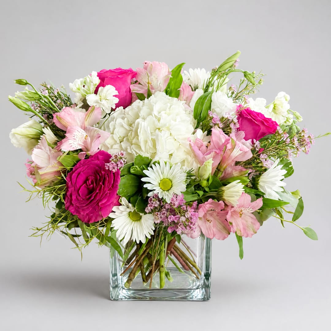 Pink and white mixed bouquet in a clear square vase