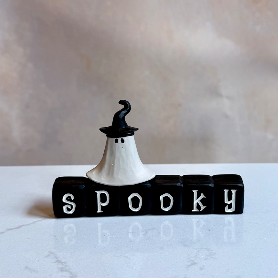 Halloween ghost figurine on blocks spelling spooky