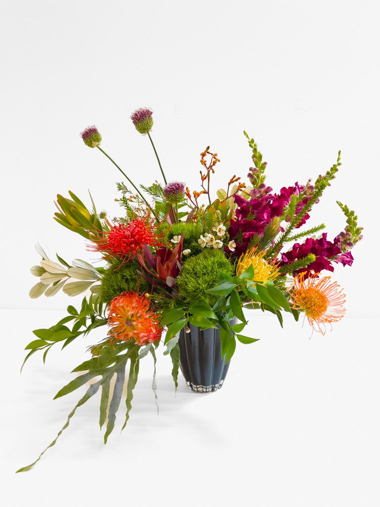 Protea Pop - A bold mix of protea, lush greens, and vibrant seasonal accents, designed with a natural, yet sculptural feel.