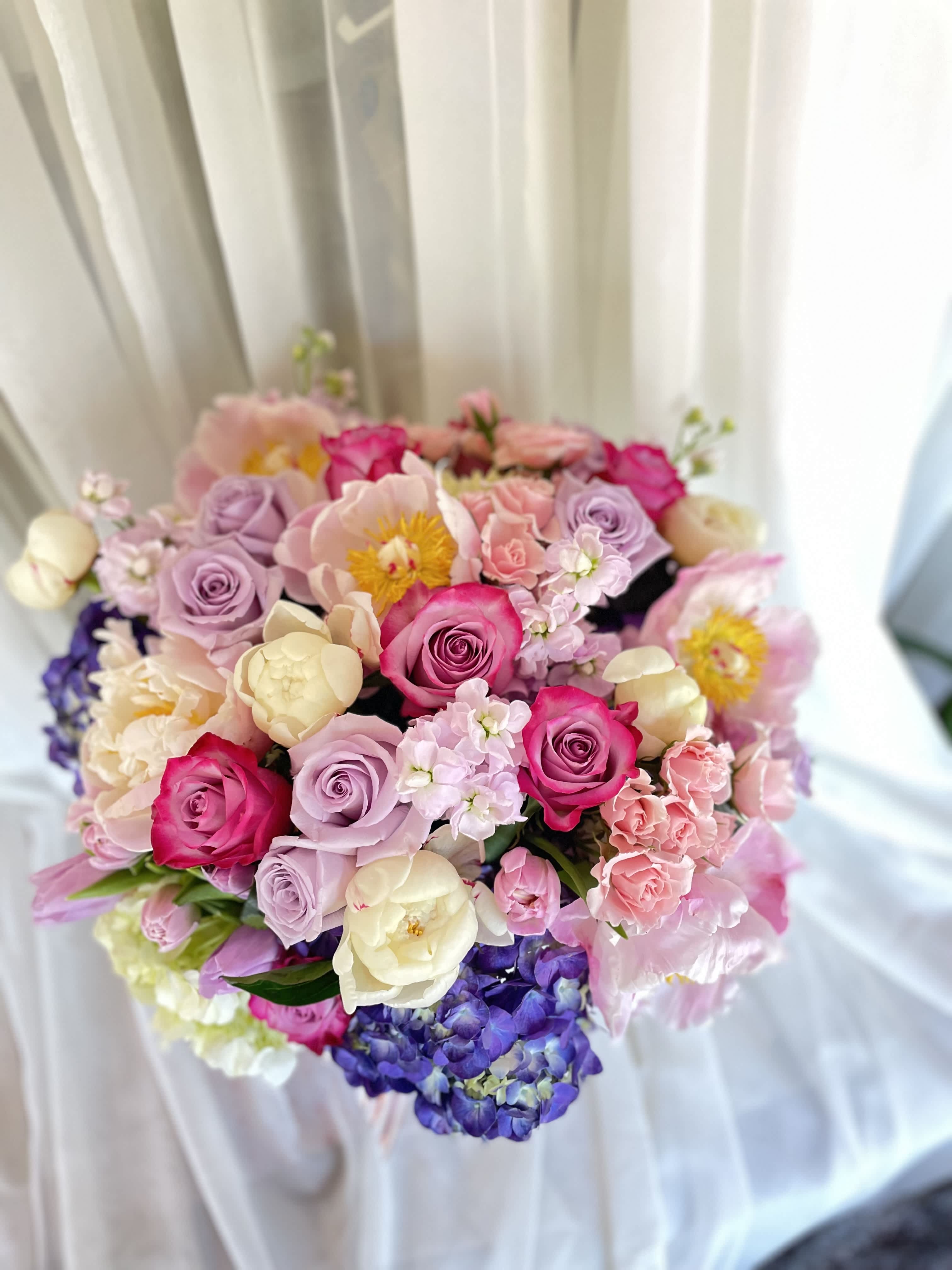 Bouquet of pink, lavender, and cream flowers with roses and hydrangeas