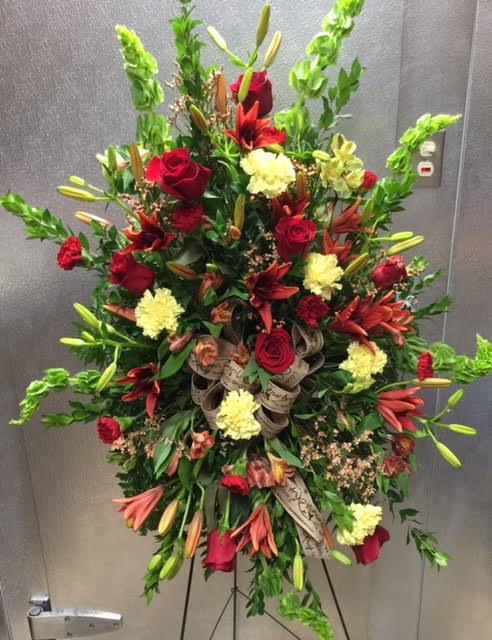 standing easel spray  - standing easel spray with bells of Ireland red roses and lilies and carnations, astro, and yellow carnations