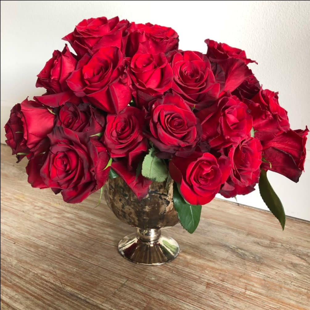 Kiss From A Rose - A modern twist on a classic. 2 dozen red roses in a low and lush urn. Red roses may be substituted for another color upon request. Vase may be substituted due to availability. 