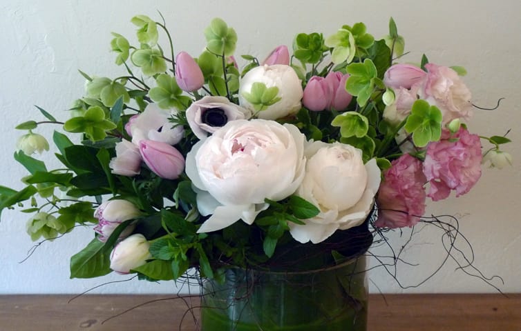 Pink and white floral arrangement in a green vase