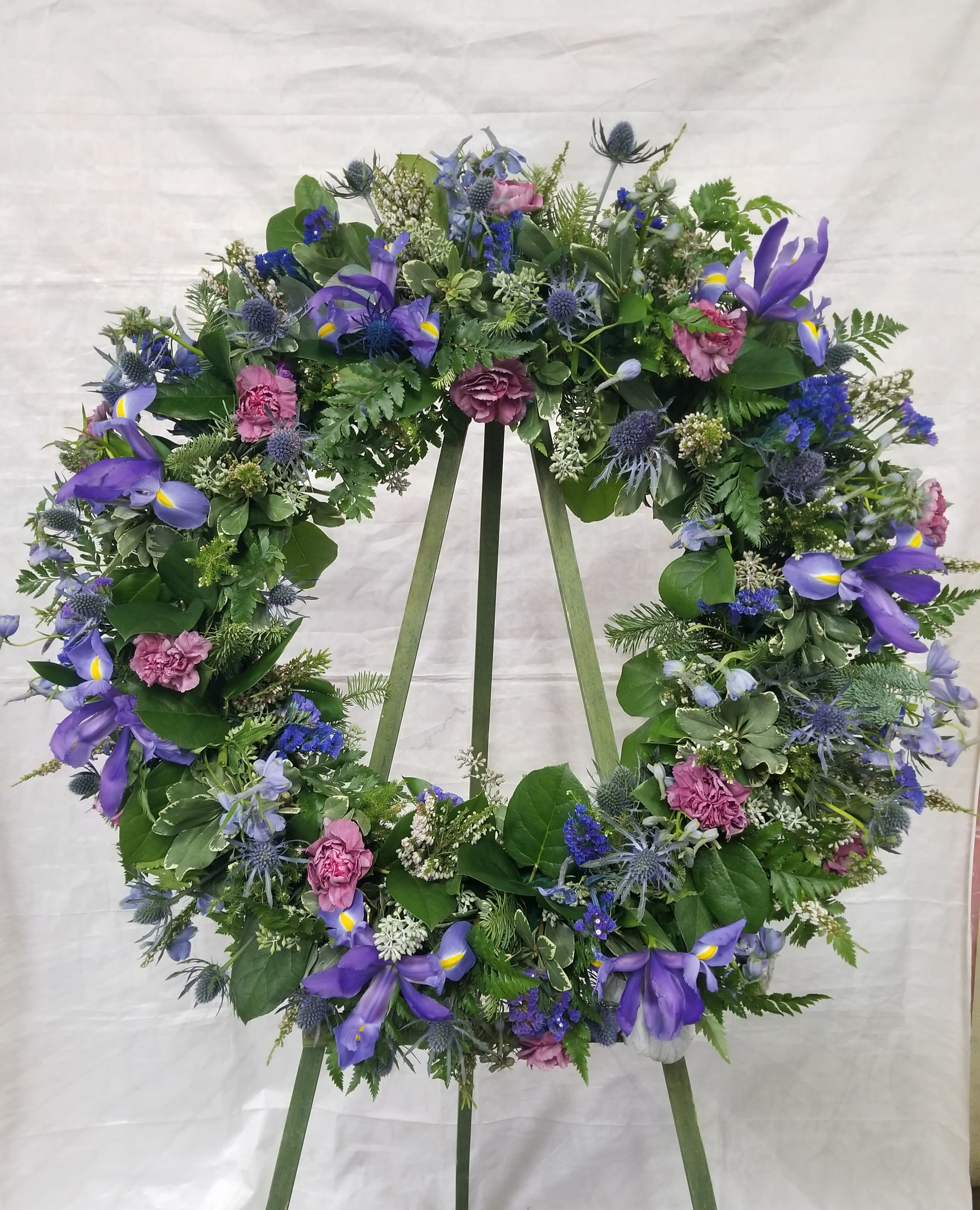 Enchanted Purple Wreath - Select this 22" sympathy wreath that includes iris, blue thistle, and carnations. 