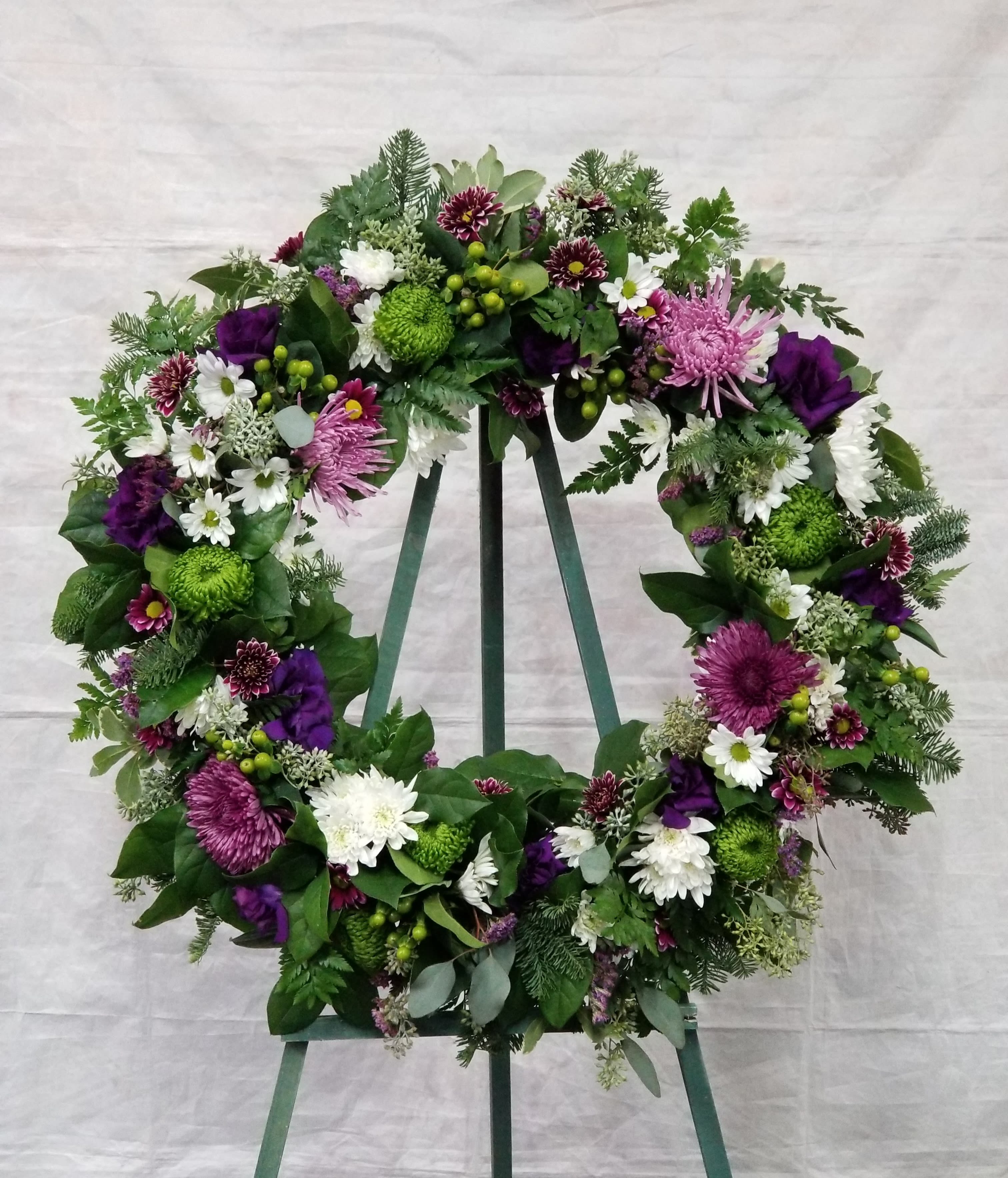 Bejeweled Wreath  - Select this 22" wreath that includes lisianthus, hypericum and more in purple, green and white. 