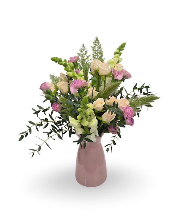 Blushing Peach - A soft and pretty mix of pastel blooms arranged in pink vase for an airy spring look. Approximately 16" x 12", this design is full of gentle color and garden-inspired texture.