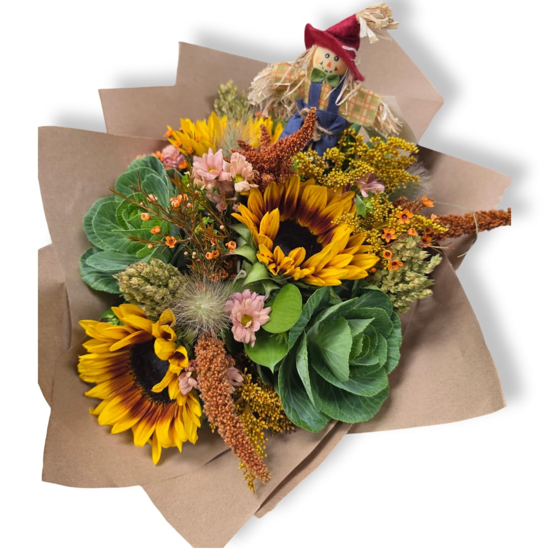 Sunflower bouquet wrapped in brown paper with a small scarecrow topper