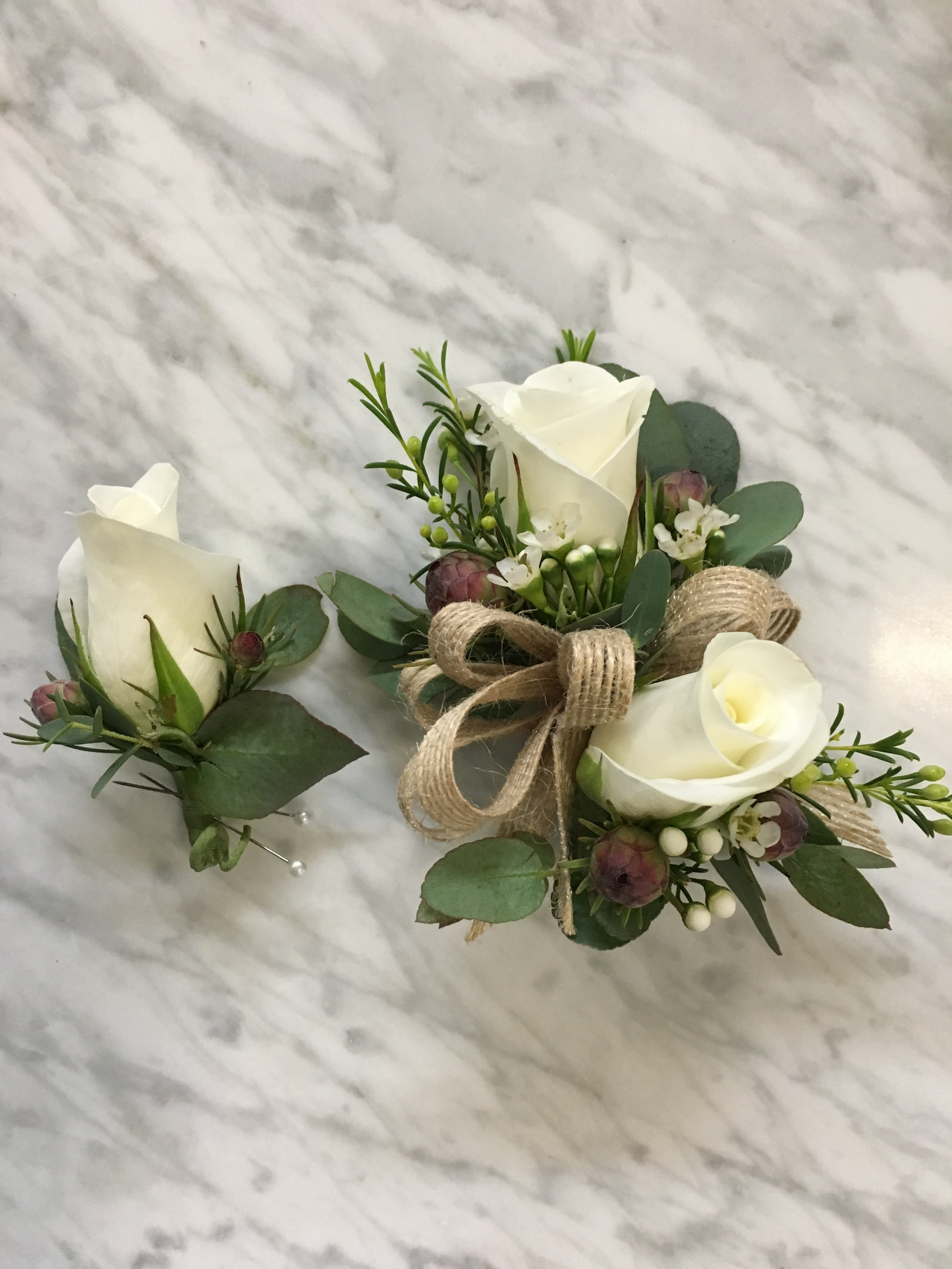 White rose boutonniere and matching wrist corsage with greenery and burlap ribbon