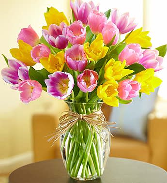 Bouquet of pink and yellow tulips in a clear glass vase