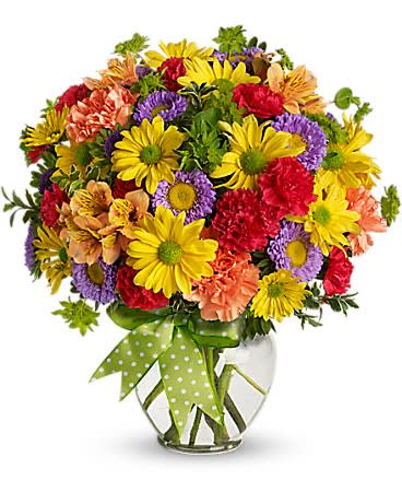 Colorful mixed bouquet in a clear glass vase with a green polka-dot ribbon