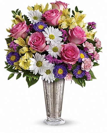 Mixed bouquet of pink roses, white daisies, and purple flowers in a silver vase