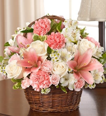 Pink and white flowers arranged in a wicker basket