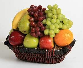 Fruit basket with grapes, bananas, apples, pears, and an orange