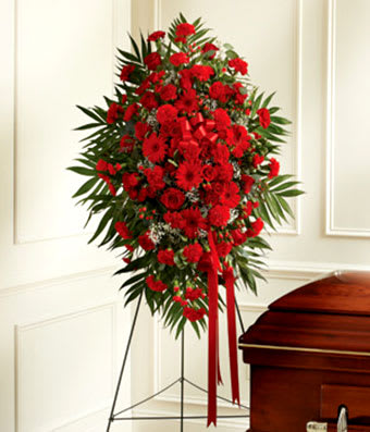 Red floral standing spray beside a casket