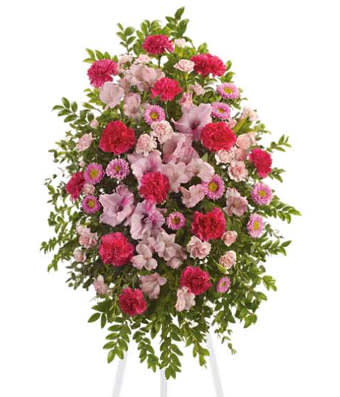 Standing spray of pink and red flowers on a white easel