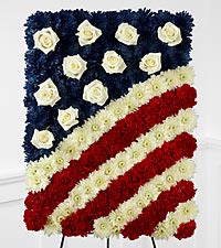 Floral tribute arranged as an American flag with red, white, and blue flowers